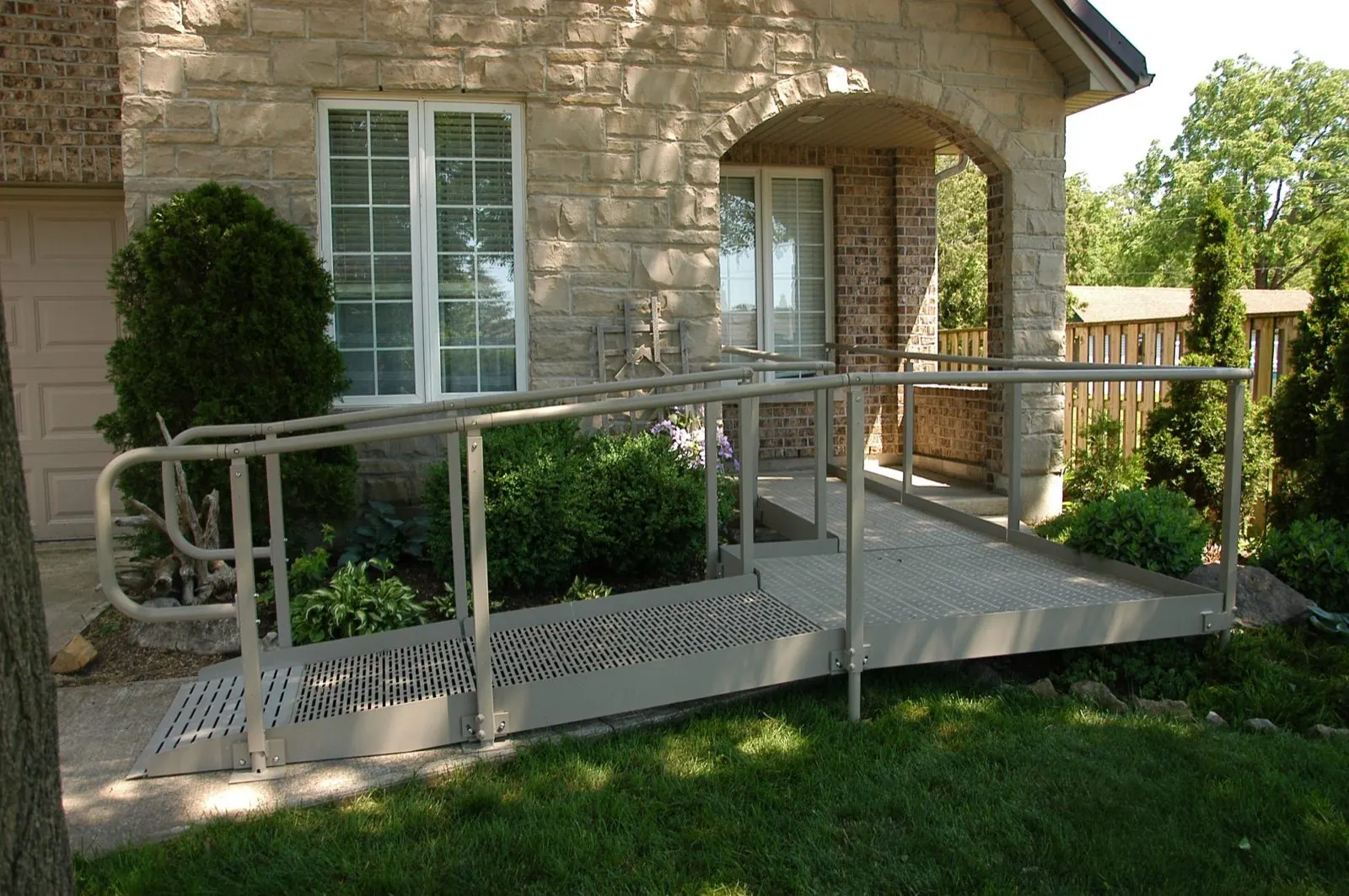 A modular ramp and handrails leading to a home entrance