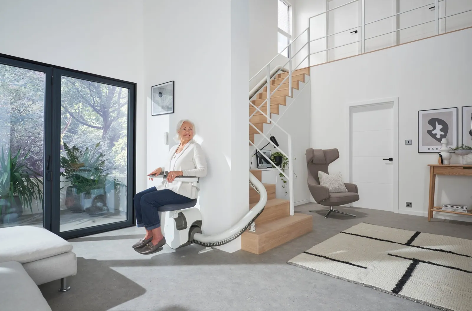 A woman using a stairlift on a curved staircase at home