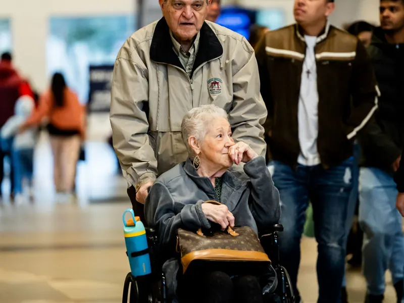 A man pushes an older woman in a wheelchair