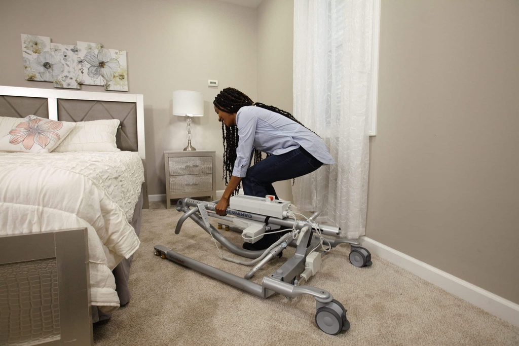 A carer folding the Carina 350 lift down for storage in a bedroom
