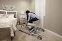 A carer folding the Carina 350 lift down for storage in a bedroom