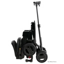 Go-Go Carbon folded and standing, with the telescoping tiller raised to roll it along