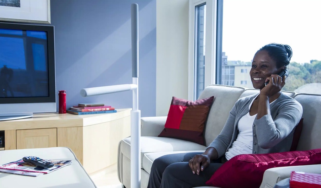 Advantage Rail bolted to the floor at the arm of a living room sofa, with a woman seated beside it