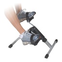 Feet in running shoes on the pedals during a seated session on the exercise peddler