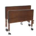 Brown head and foot panels of an example hospital bed, on casters