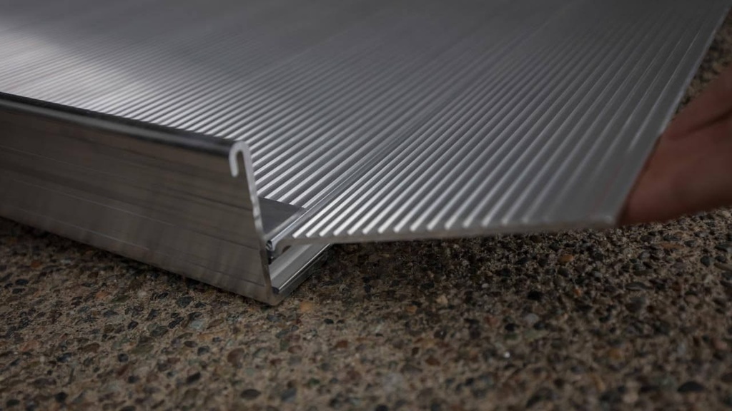 Integrated side curb and lower transition plate where the ramp deck meets the ground