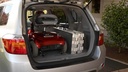 Ramp folded flat on edge beside a scooter in an SUV cargo area