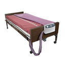 Med-Aire 8 system on a wooden hospital bed with the cover folded back and pump on the footboard