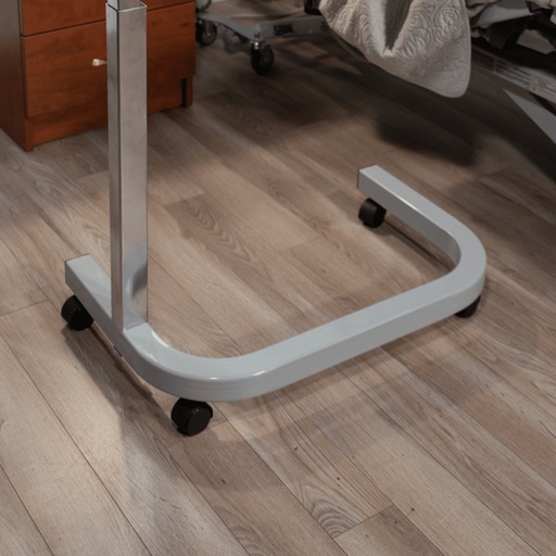 The SPAN overbed table's C-shaped base and chrome column on black casters, seen on a wood floor
