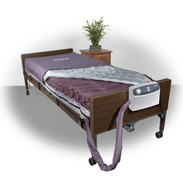 Med-Aire 8 mattress on a bed under a quilt, with the pump hung at the footboard