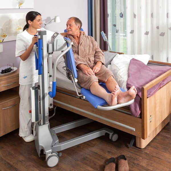 A resident on the stretcher version of the Senta PUR L, with a carer at the control box