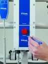 Hand using a pen in the emergency hole on the blue Invacare control box