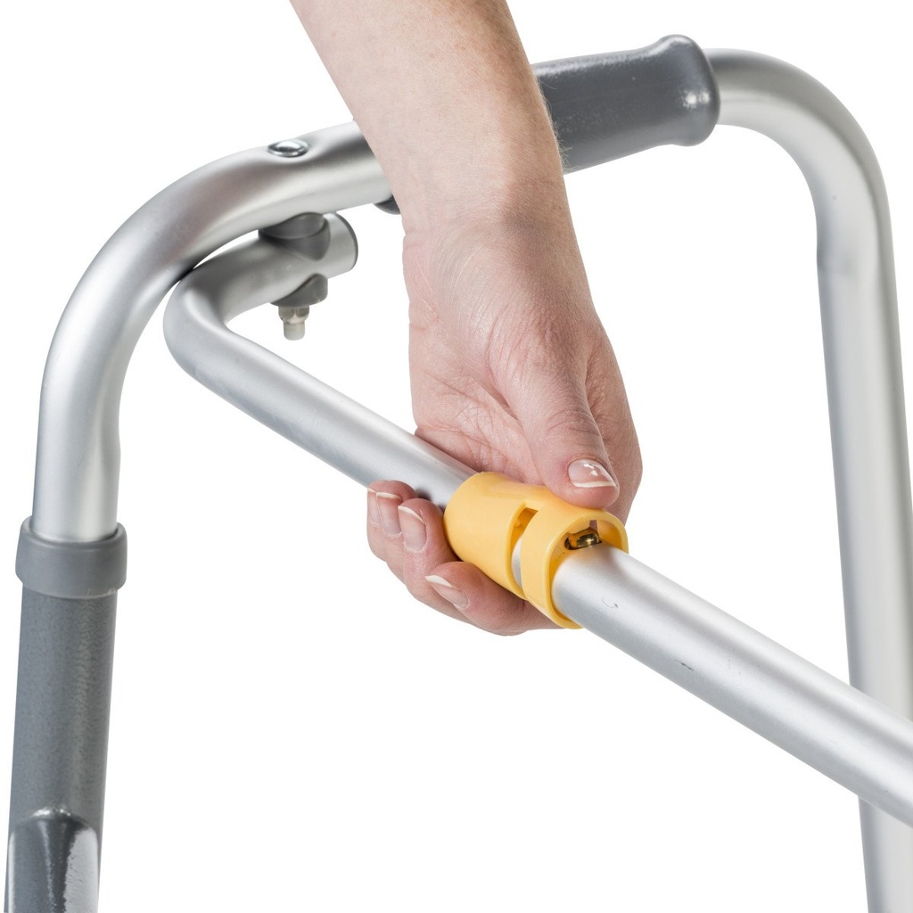 Hand pressing the yellow button on the front bar of the silver walker