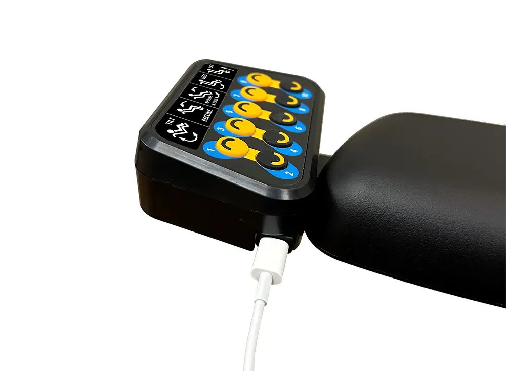 Switch-It CTRL+5 box on an armrest with a USB-C cable plugged in