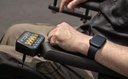Hand pressing the CTRL+5 seating control on a power chair armrest