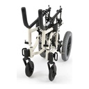 The white TS frame folded, seat and back off, with one rear wheel still mounted