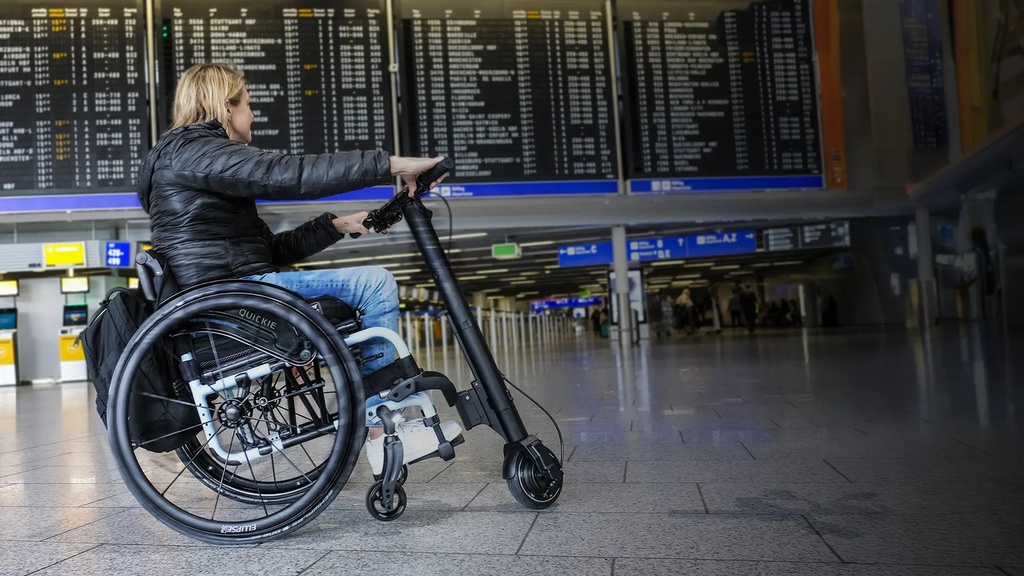 Empulse F35 in an airport hall, rider holding the handlebar, drive wheel ahead of the chair