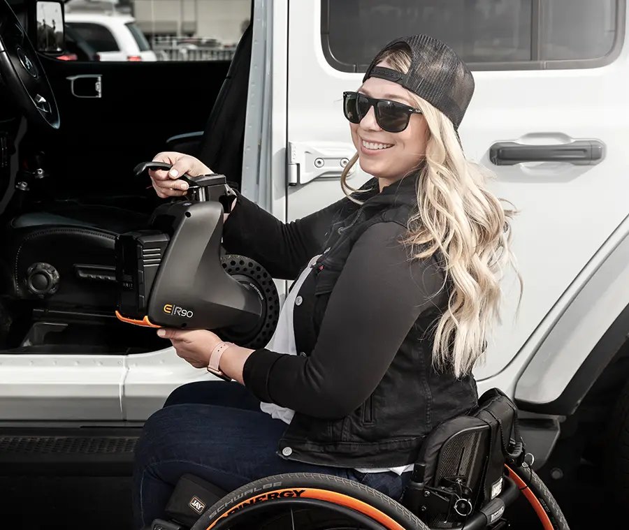 Empulse R90 lifted by its handle, off the chair, beside a vehicle