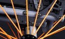 Close view of the Match Point axle plate, with orange spokes in front