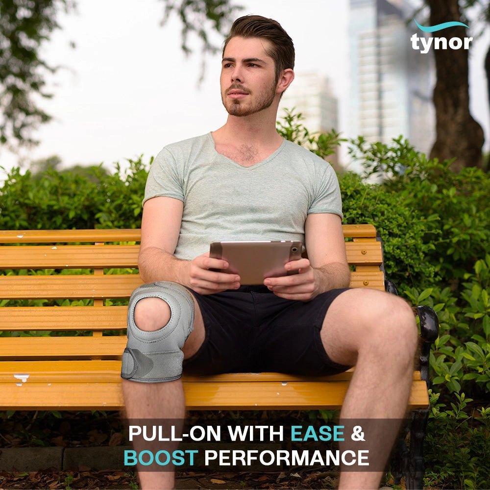 Man sitting on a park bench wearing a Tynor Sportif Neo knee sleeve on his right knee