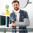 Man standing in an office holding a phone, wearing a Tynor Pouch Arm Sling