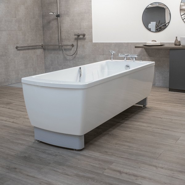 Avero Comfort tub in a tiled bathing room, beside a wall rail and a hand shower