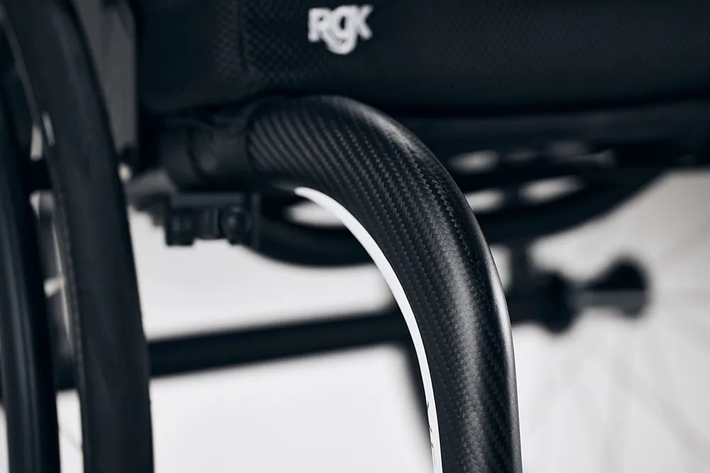 Carbon fibre weave on the frame tube of an RGK Veypr Sub4 wheelchair, with the logo above it