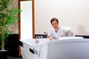 A carer beside a resident seated in the Beka Avero Motion E care tub