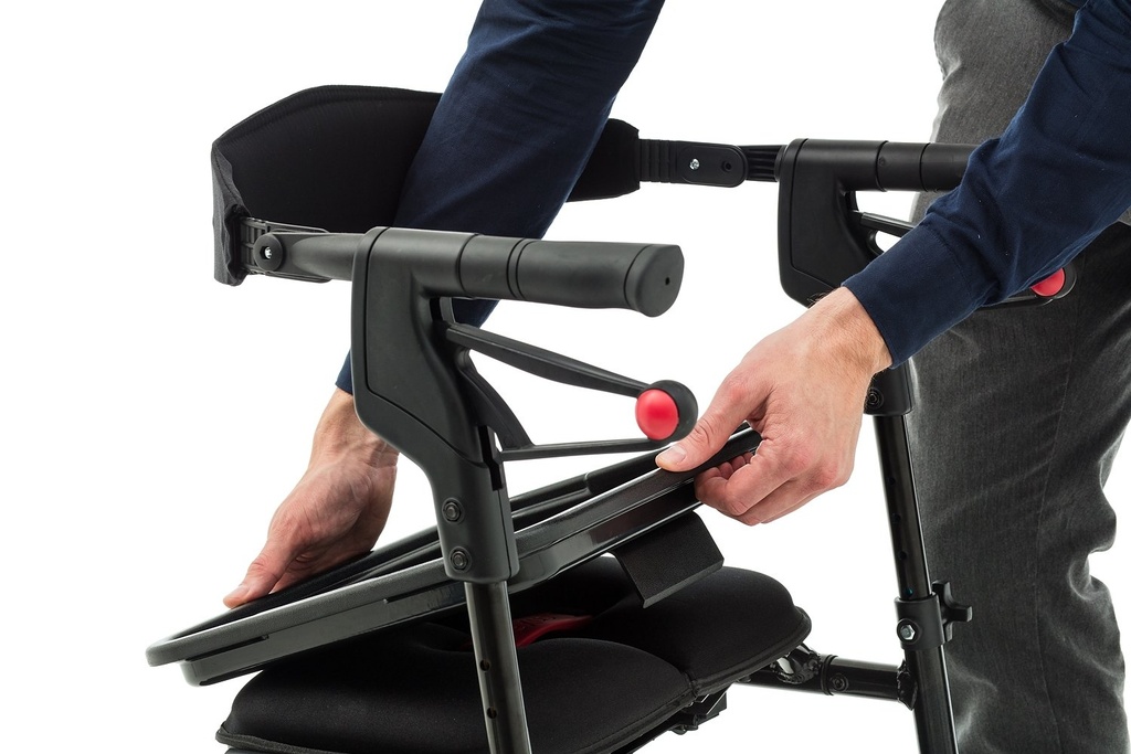 Hands pressing the neXus tray onto the seat of a rollator