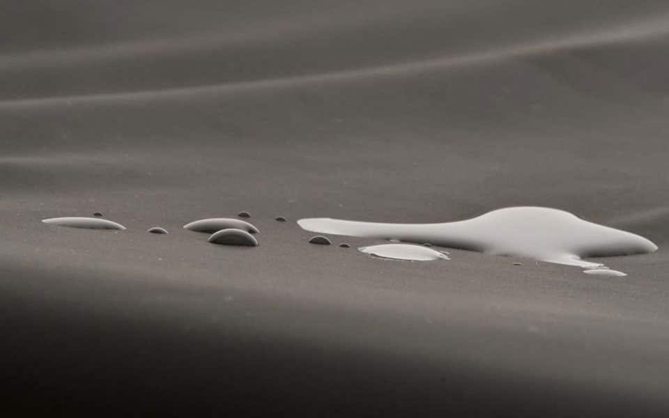 Close-up of water beading on the dark Dartex-coated cover of the JAY GO cushion