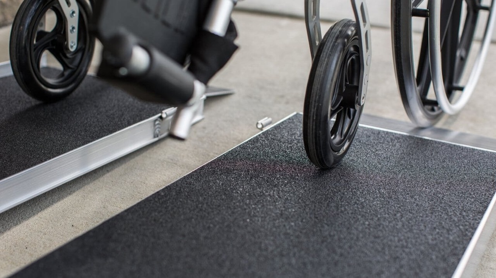 Wheelchair wheels on the black applied surface of the EZ-ACCESS SUITCASE AS ramp