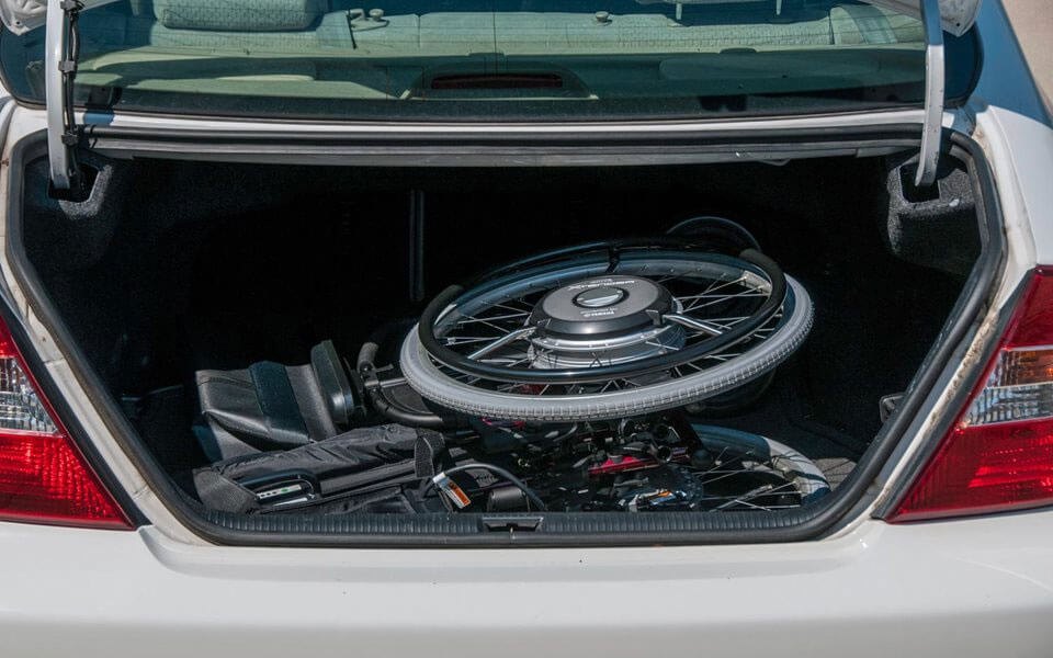 Quickie Xtender wheel units and parts packed flat in the boot of a car