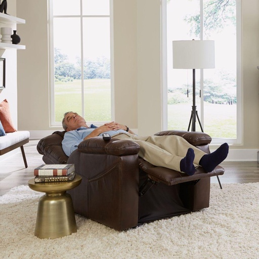 Person reclined in a brown Rhea lift chair with the footrest raised