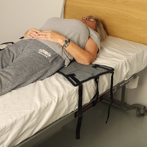 Tri-Turner sling slid under the lower back with its straps over the bed edge