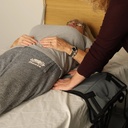 Carer anchoring the Tri-Turner sling under the lower back before a turn