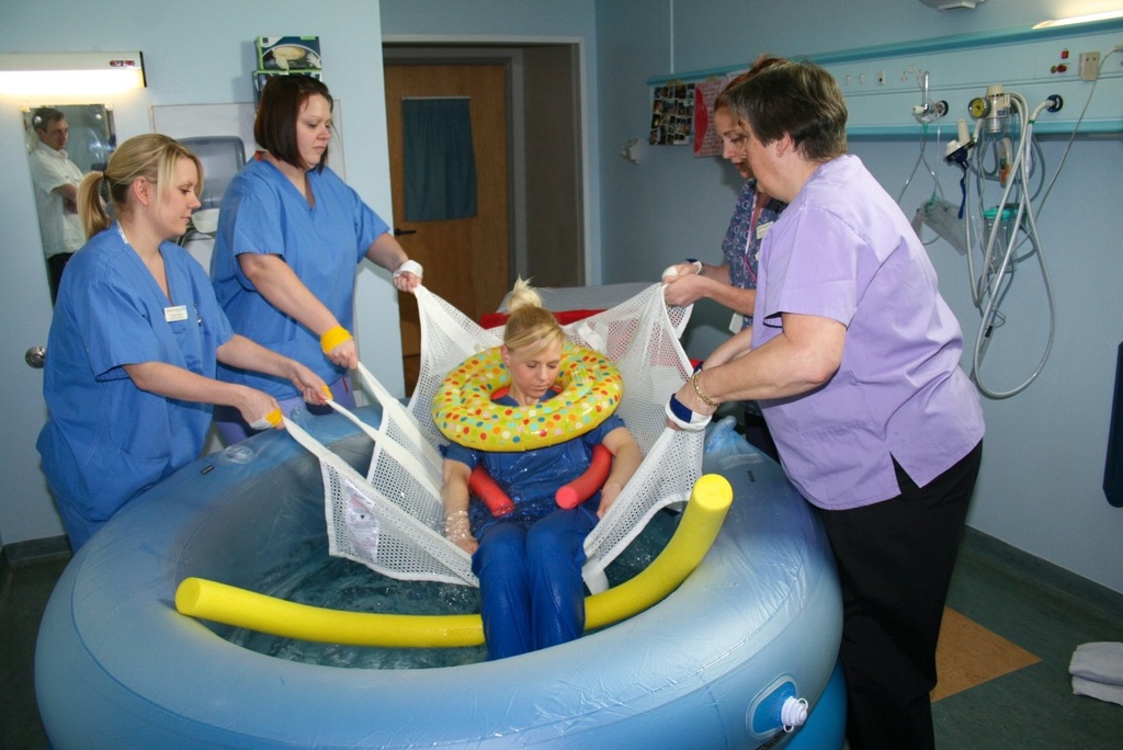 Four caregivers evacuating a person from a birthing pool with the BIRTH1 sling