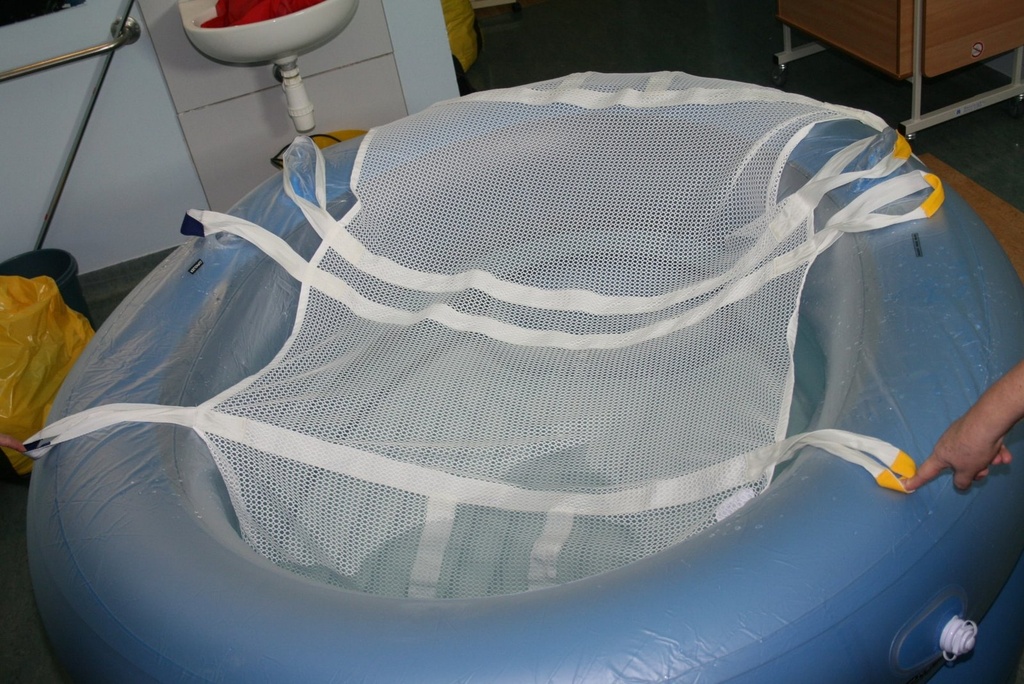 BIRTH1 birthing sling laid in a pool, with colour-coded handles on each side