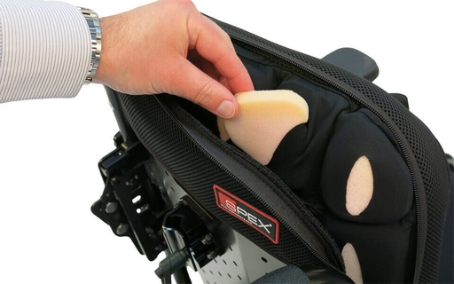 Hand inserting a foam contouring cube into the open top of the Spex Standard back support