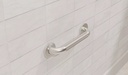 Knurled grip and round flange on a white tiled bathroom wall