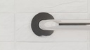 Round polished chrome flange where the smooth rail meets the wall