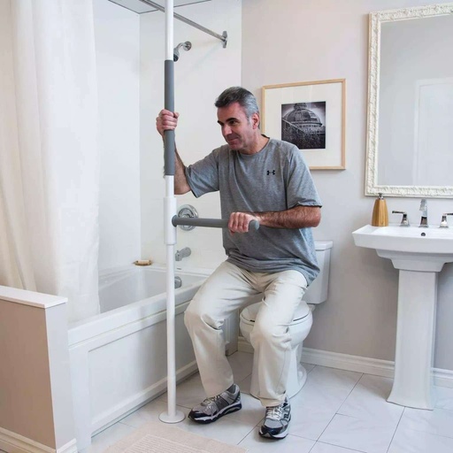 Man seated on a toilet, one hand on the pole grip and the other on the SuperBar in front of him